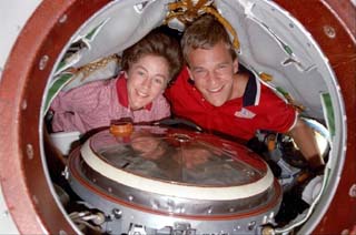 STS-86 mission specialists Scott Parazynski and Wendy Lawrence look out of the hatch of the Soyuz spacecraft which is docked to the Mir space station. 